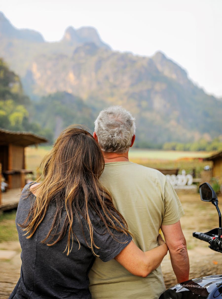 Mature couple looking at the mountains, photo from the back